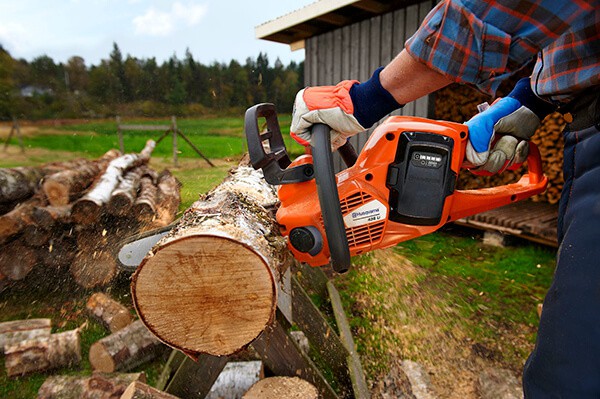 Man using chainsaw to cut for firewood